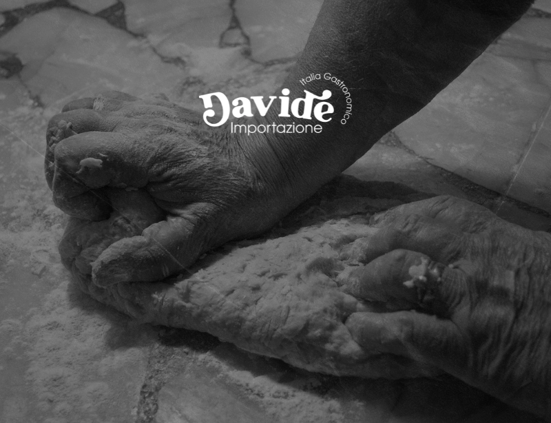 Manos amasando harina sobre una mesa de mármol, en blanco y negro, con el logotipo de Davide Importazione, branding de KLOROFiLA