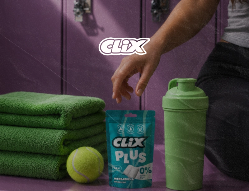 Chicles Clix Plus sin azúcar junto a toallas, pelota de tenis y botella deportiva en un vestuario, proyecto de KLOROFiLA