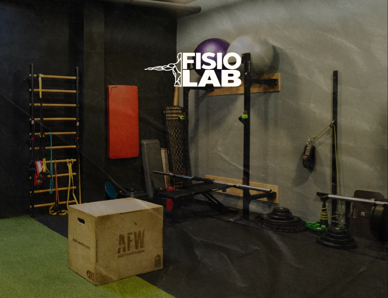 Sala de entrenamiento con espalderas, fitballs y cajón pliométrico con el logotipo de FisioLab, diseño web de KLOROFiLA