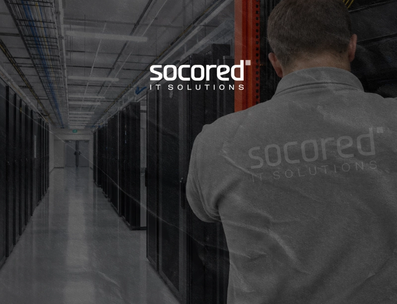 Técnico de Socored IT Solutions de espaldas en el pasillo de un centro de datos con racks de servidores, proyecto de KLOROFiLA