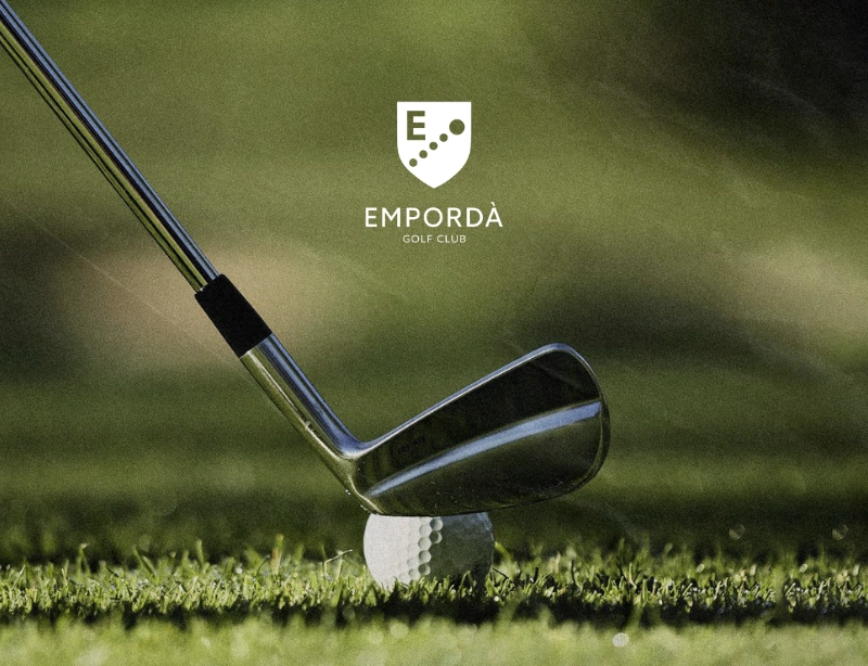 Palo de golf a punto de golpear la bola sobre el césped con el logotipo de Empordà Golf Club, proyecto de SEO y web de KLOROFiLA