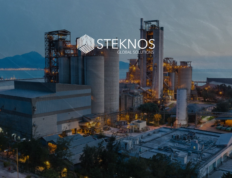 Planta industrial con silos al anochecer y el logotipo de Steknos Global Solutions, proyecto de marketing industrial de KLOROFiLA