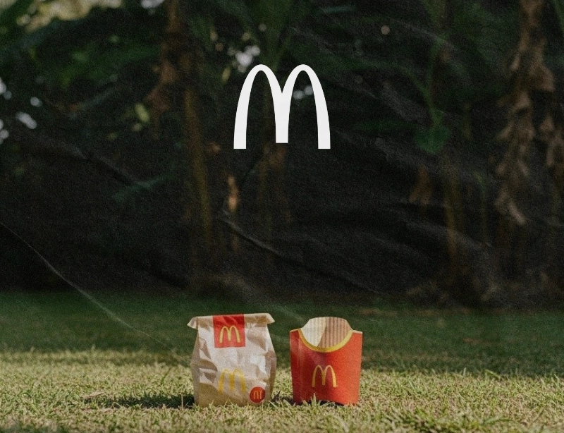 Bolsa de papel y caja de patatas fritas de McDonald's sobre el césped, proyecto de marketing local y redes sociales de KLOROFiLA